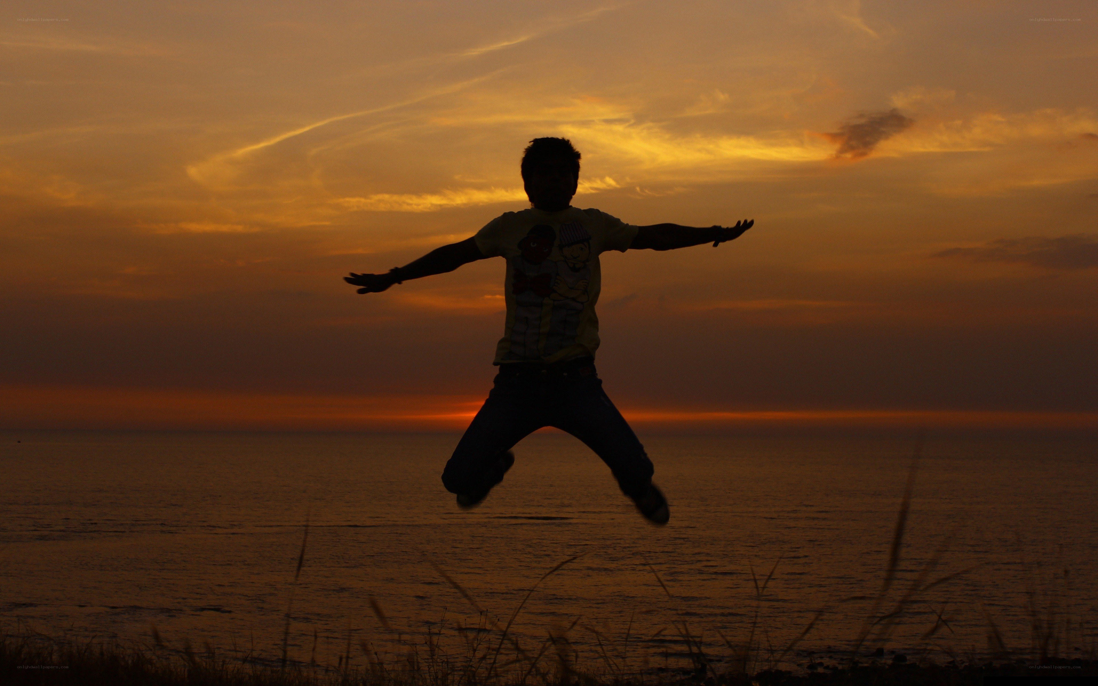 Person jumping at sunset