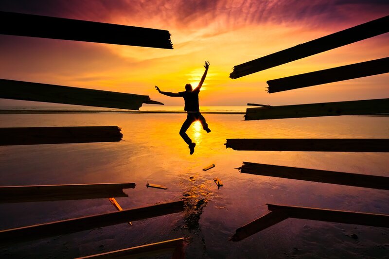Person jumping at sunset