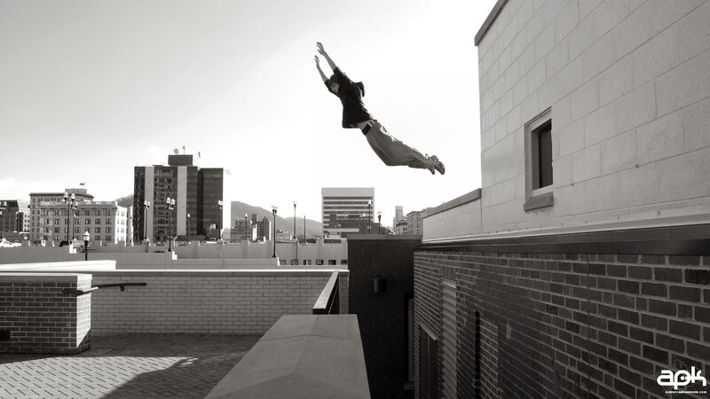 person jumping between buildings