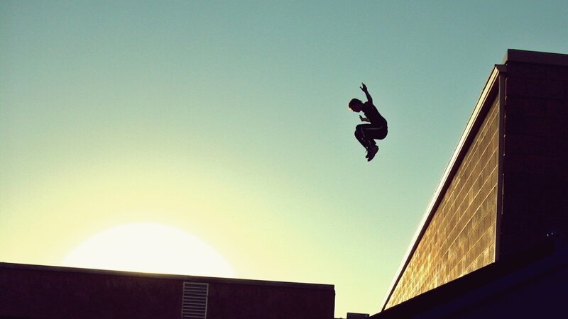 person jumping between buildings