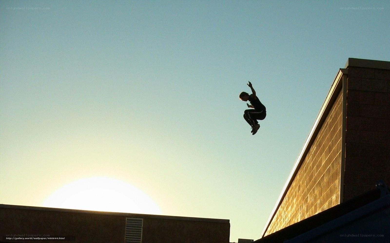 person jumping between buildings