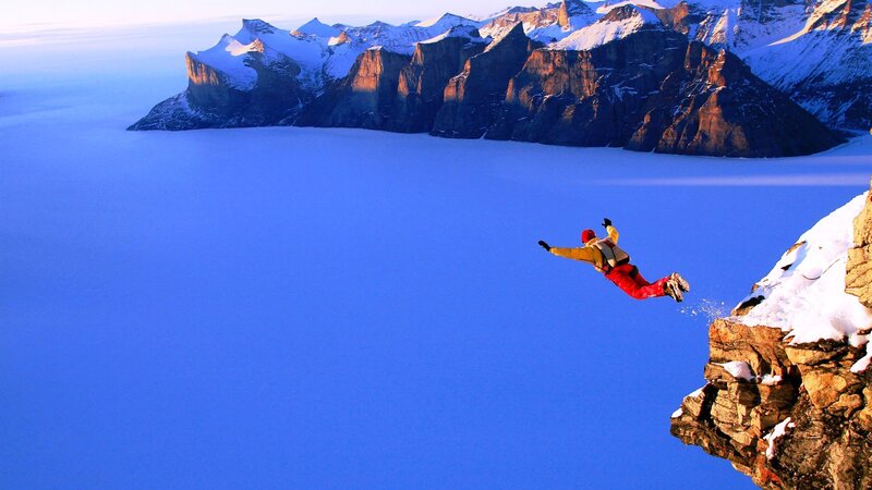 Person Jumping from Cliff — Blue