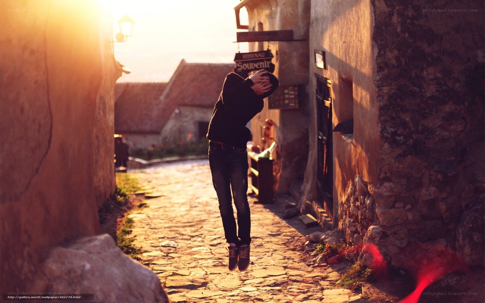 Person jumping in alley at sunset
