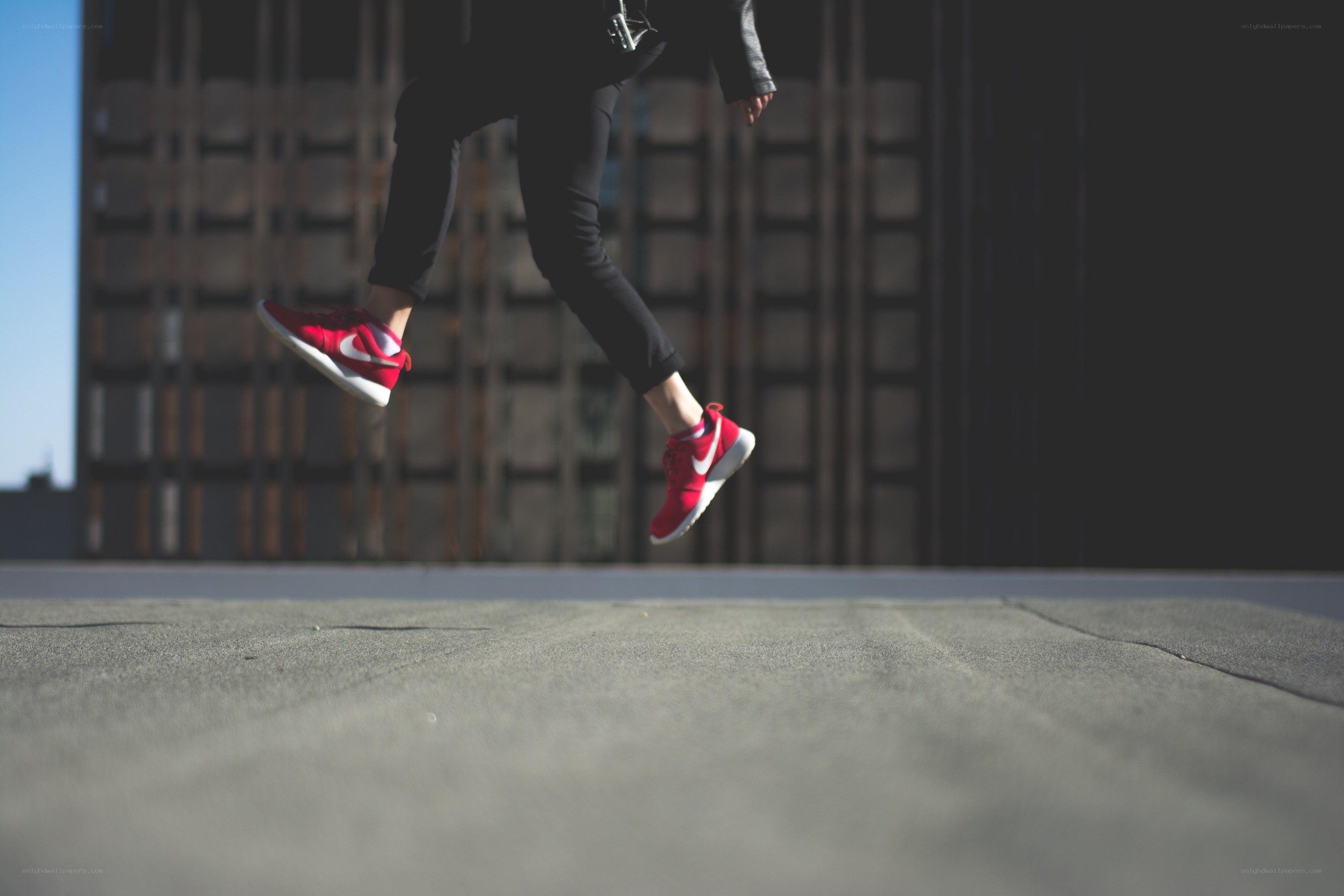 person jumping in red sneakers