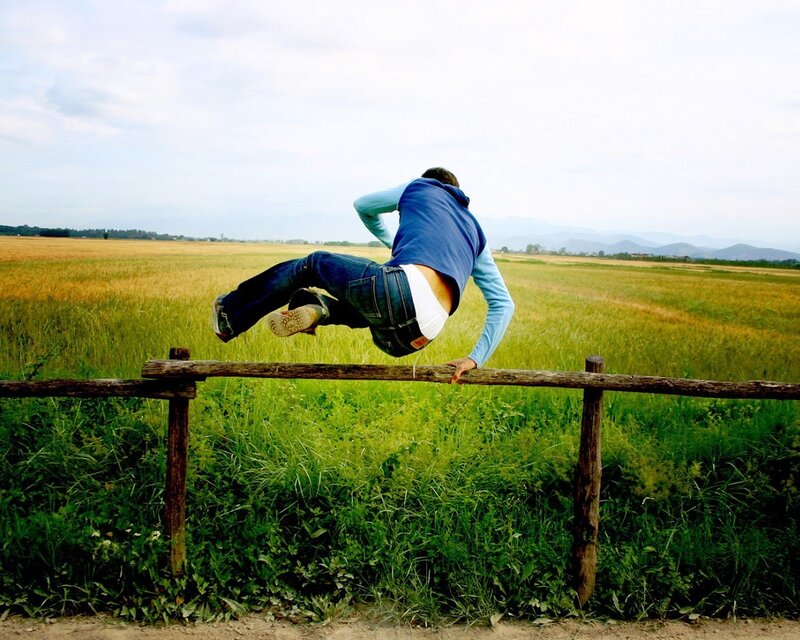 Person jumping over a fence