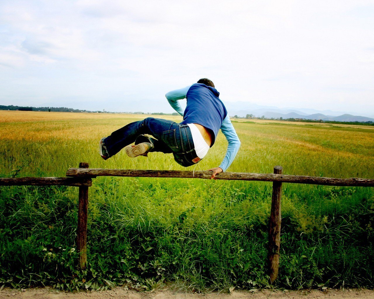 Person jumping over a fence