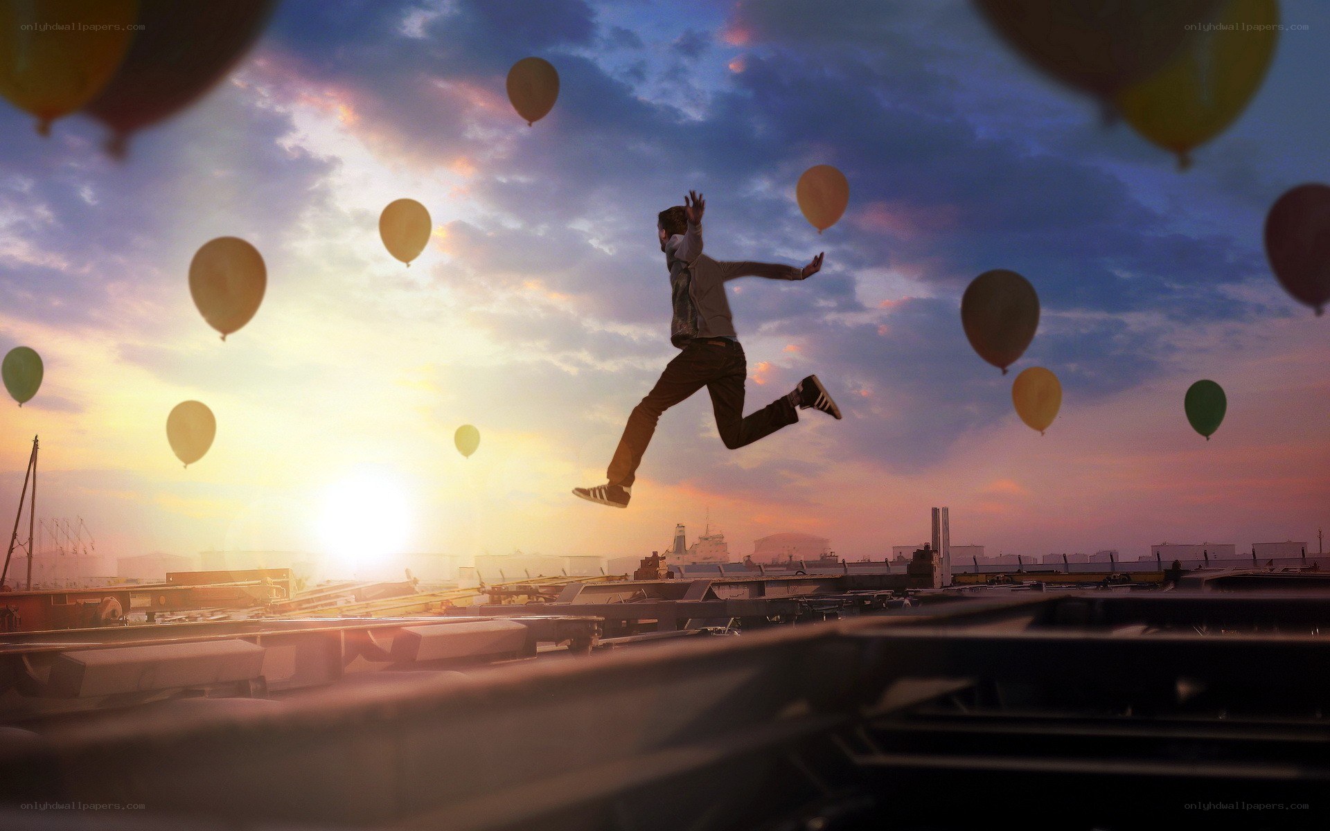 Person jumping with balloons at sunset