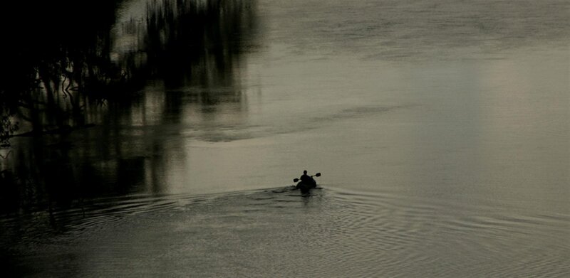 Person kayaking on a calm river