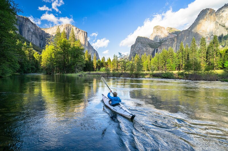 Person Kayaking on River — Blue