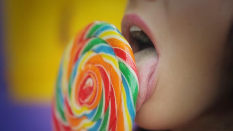 person licking a lollipop