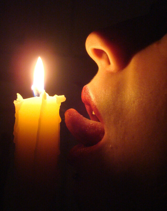 person licking candle flame