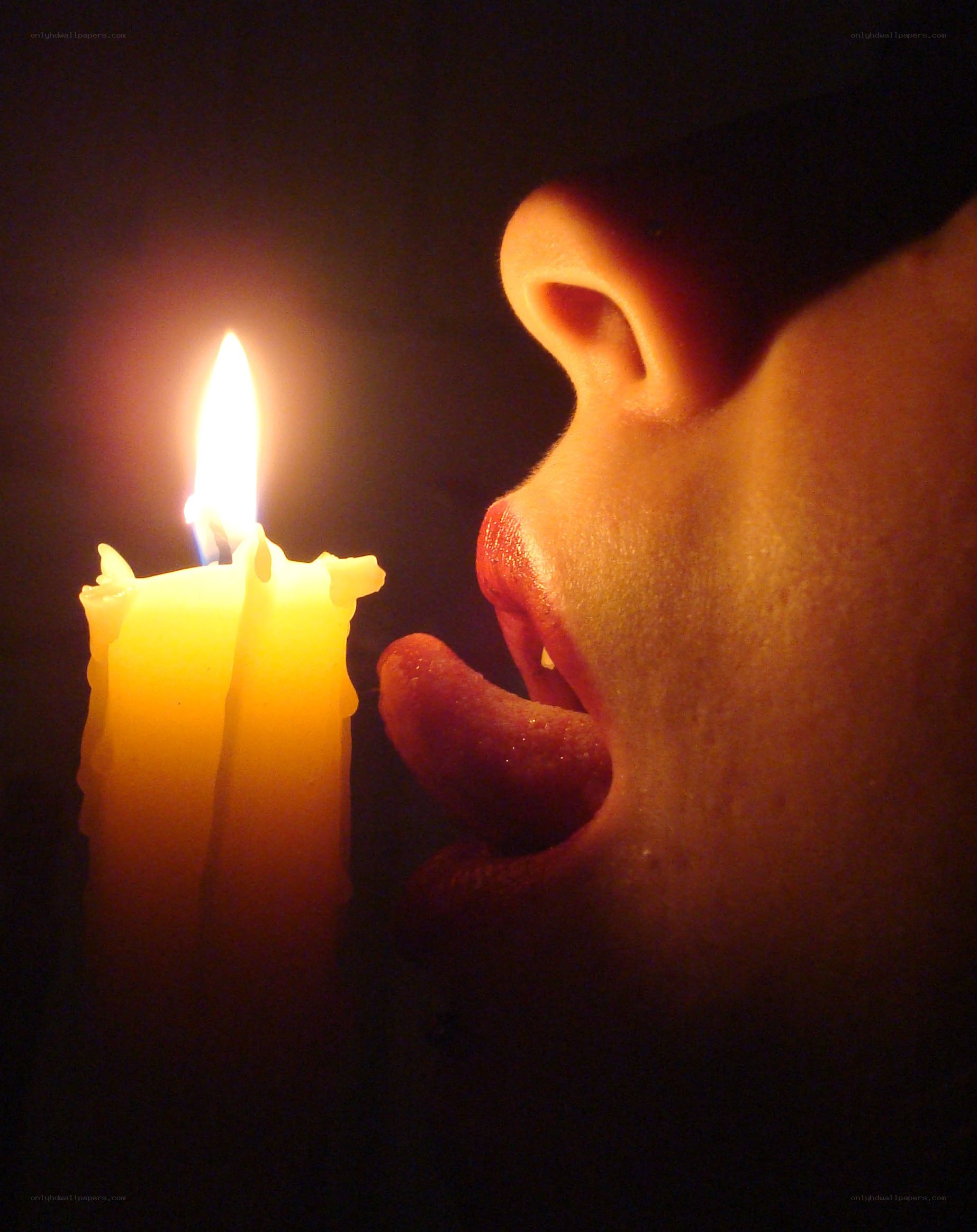 person licking candle flame