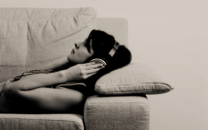person listening to music on couch