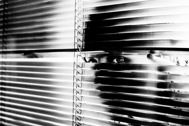 Person Looking Through Blinds