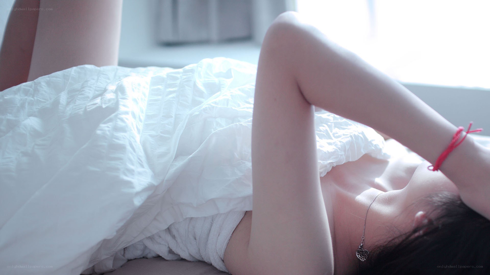 person lying in bed with white blanket