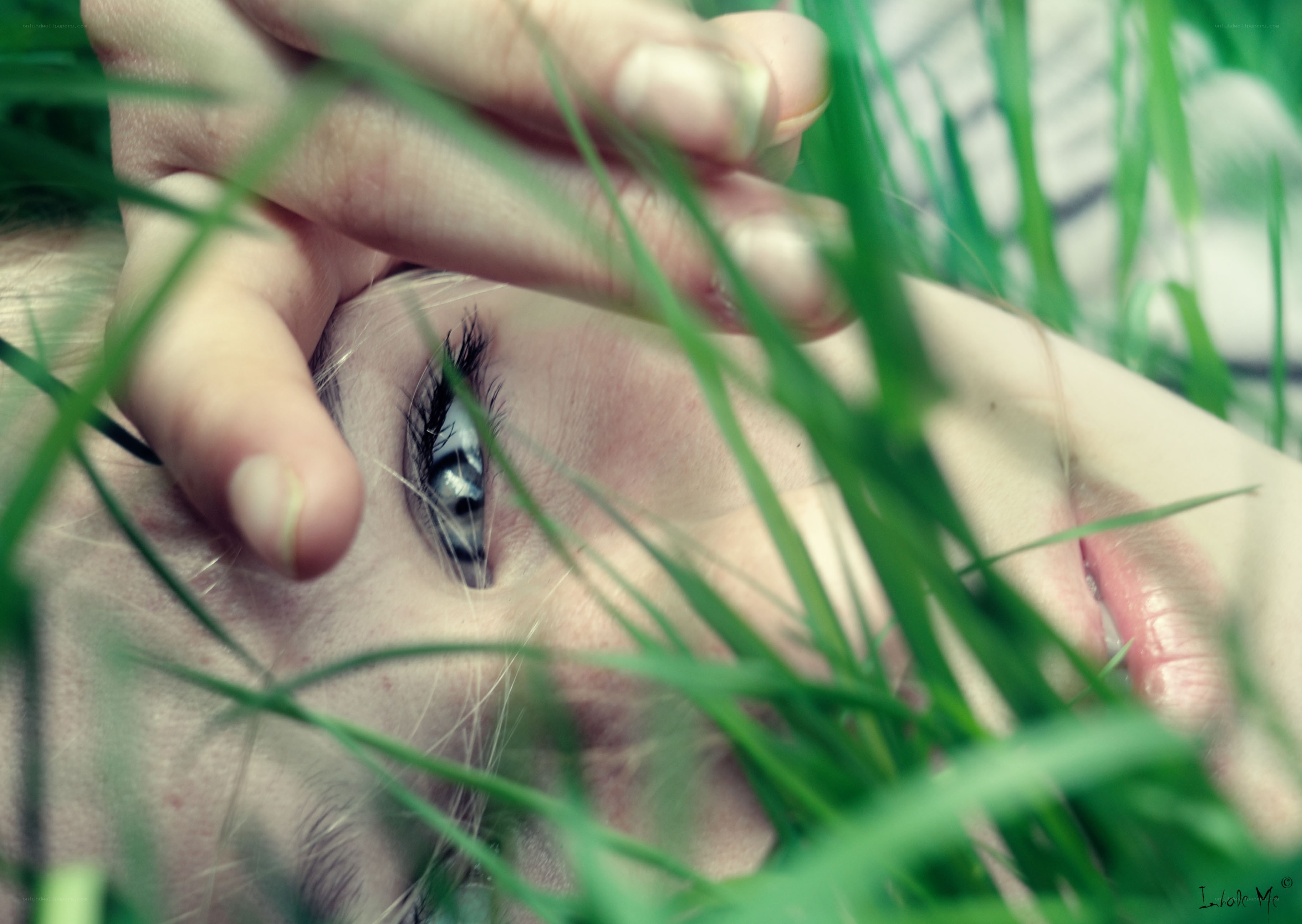 person lying in grass with eye visible