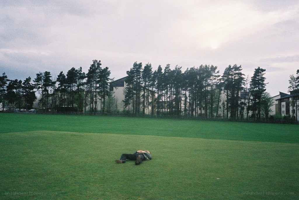 Person lying on a grassy field