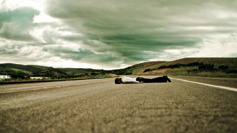 Person lying on a road