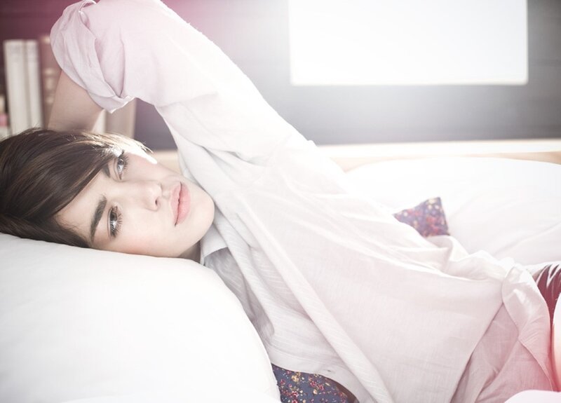 person lying on bed in sunlight