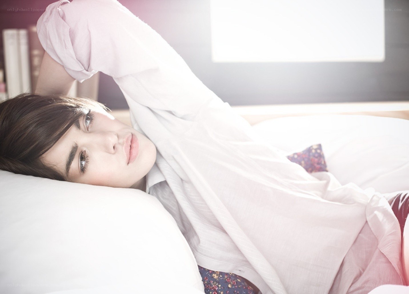 person lying on bed in sunlight