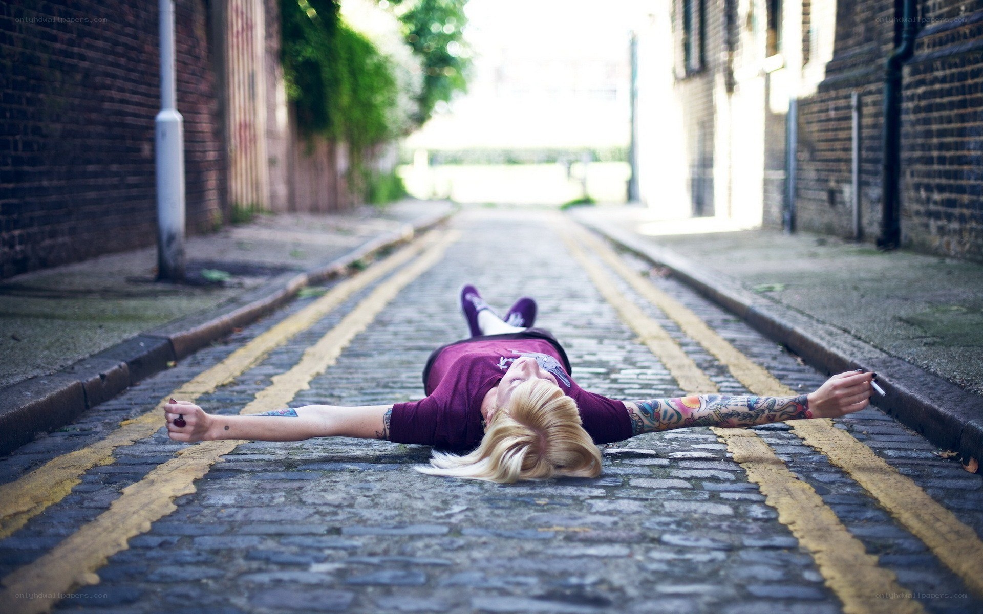 person lying on cobblestone street