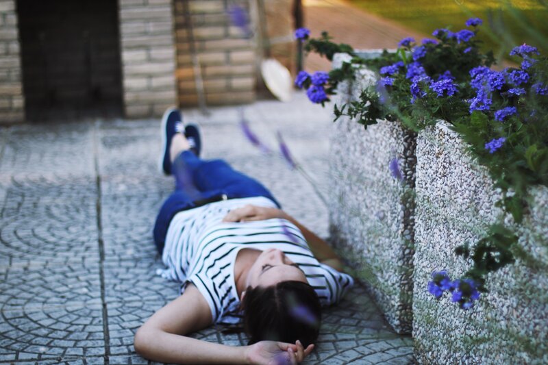 person lying on cobblestone