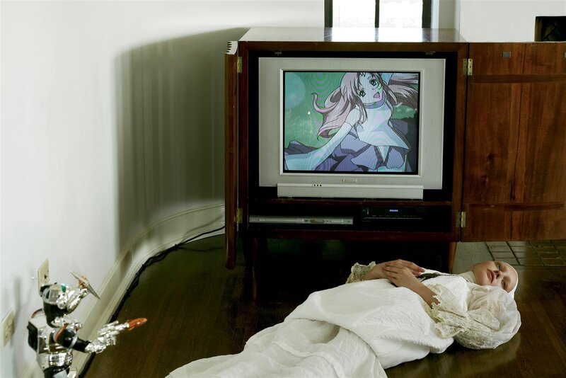 Person lying on floor watching anime