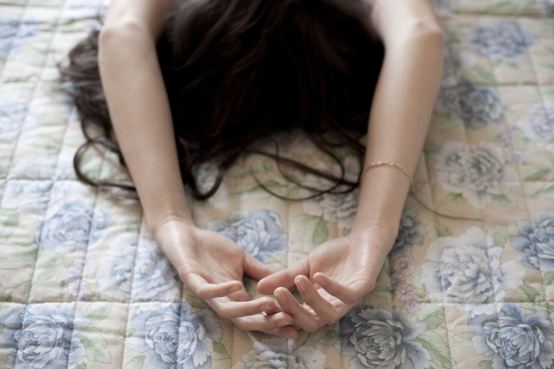 person lying on floral bedspread