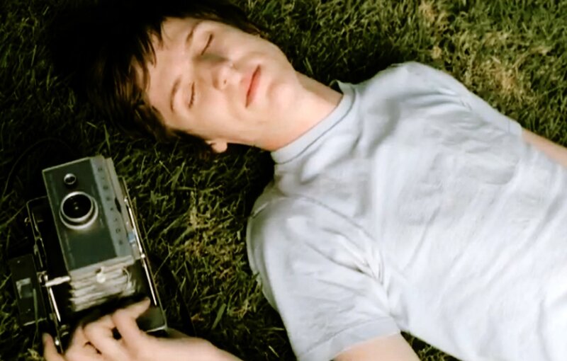 person lying on grass with camera