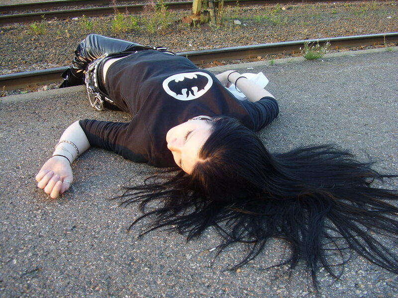 person lying on ground near tracks