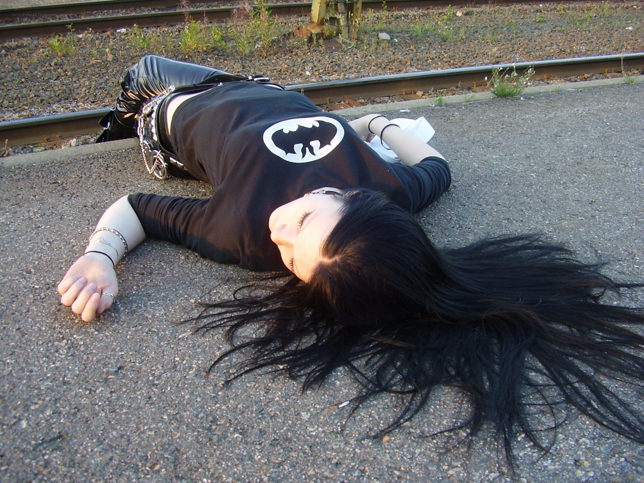 person lying on ground near tracks