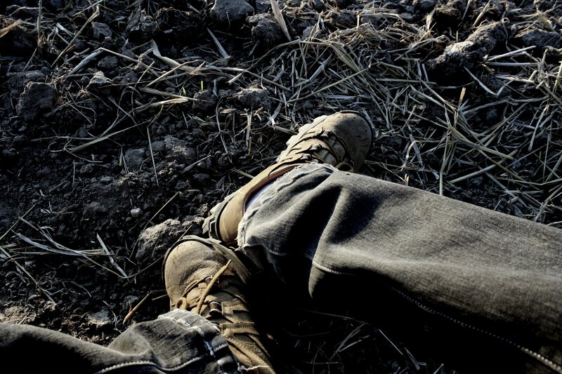 person lying on muddy ground