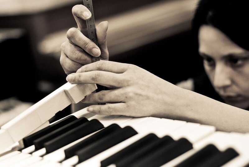 person measuring piano keys