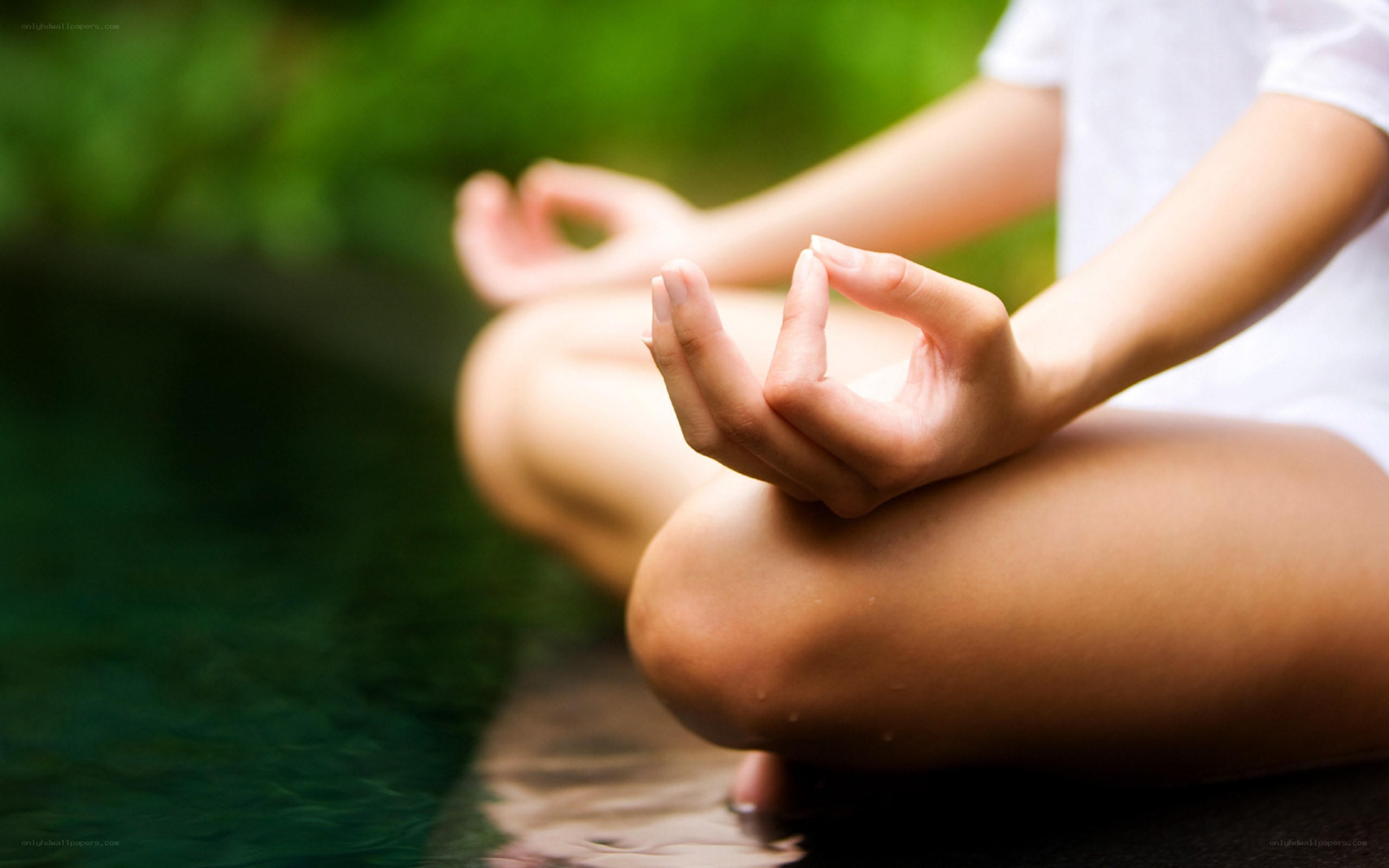 person meditating by water