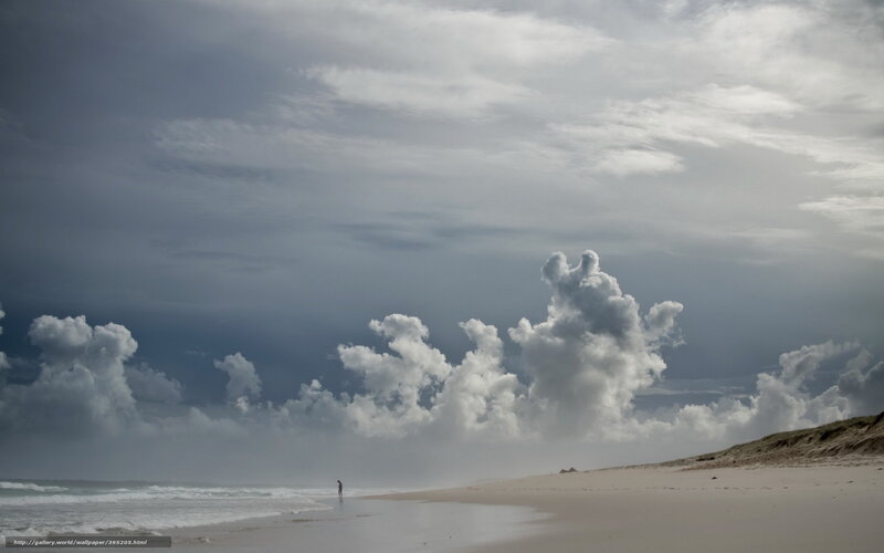Person on a beach under cloudy sky