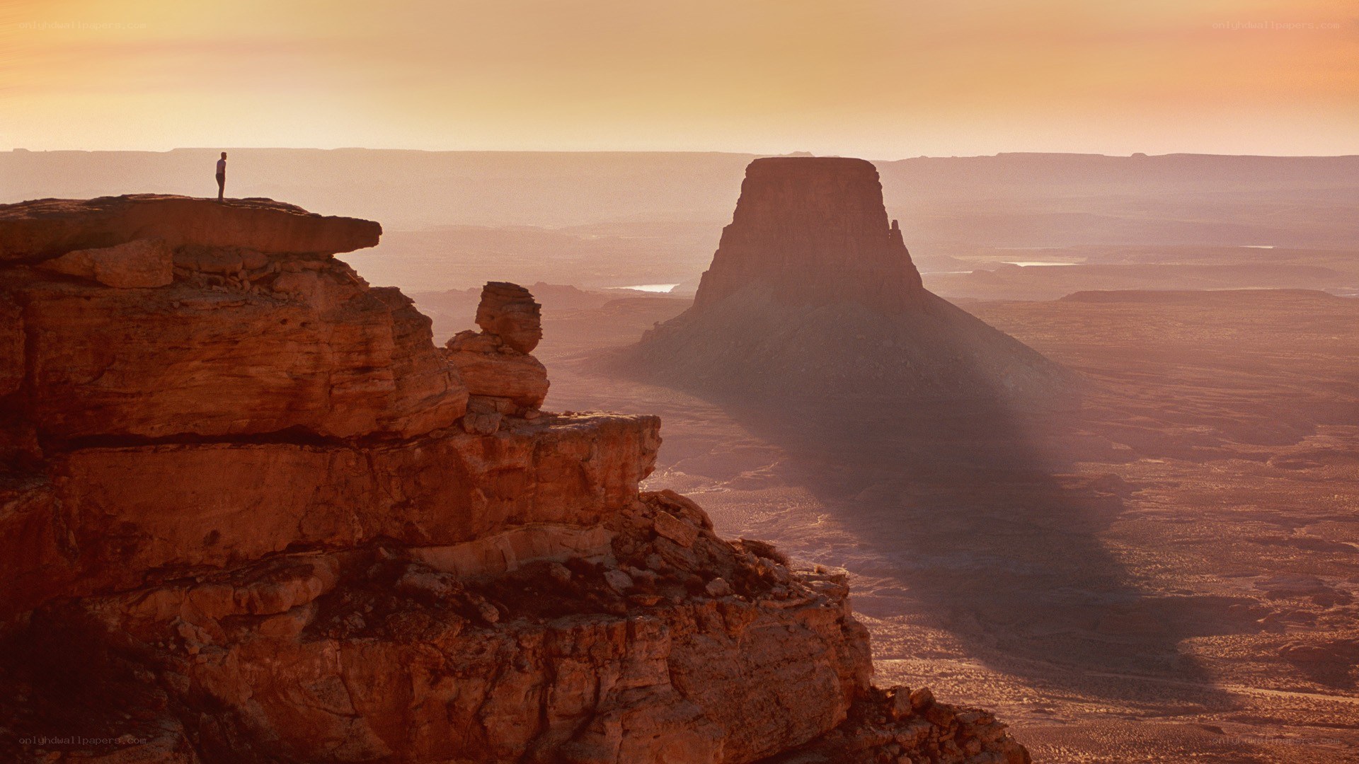 Person on a cliff at sunset