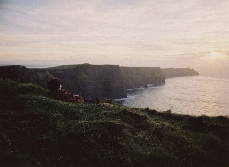 Person on a cliff overlooking the sea