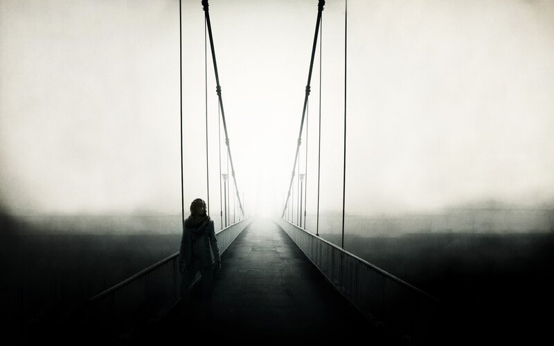 person on a foggy bridge