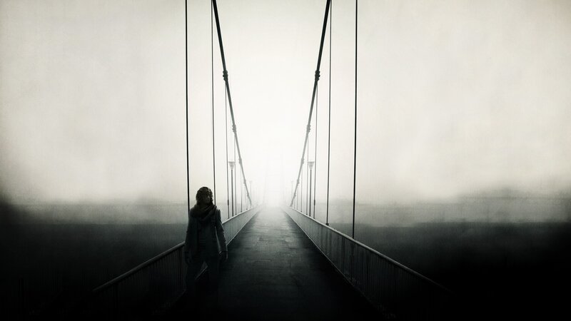 person on a foggy bridge