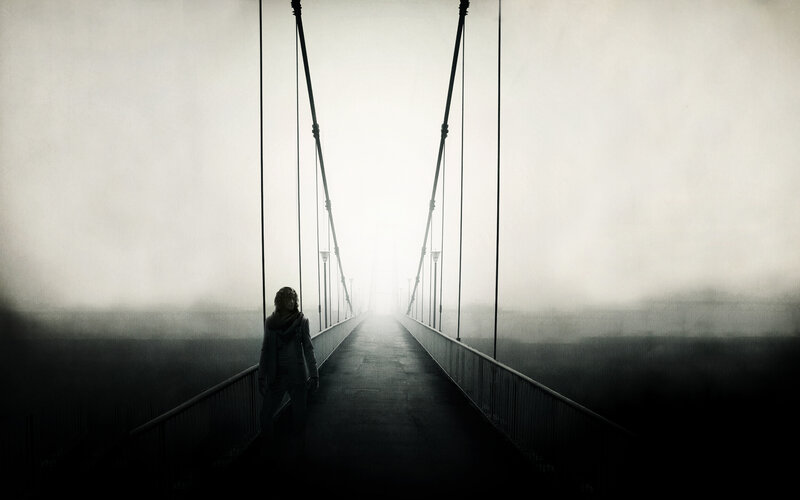 person on a foggy bridge