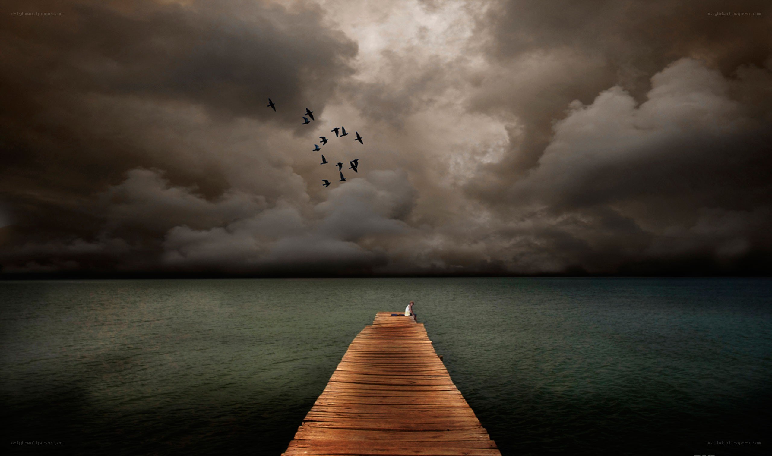 Person on a pier under stormy sky