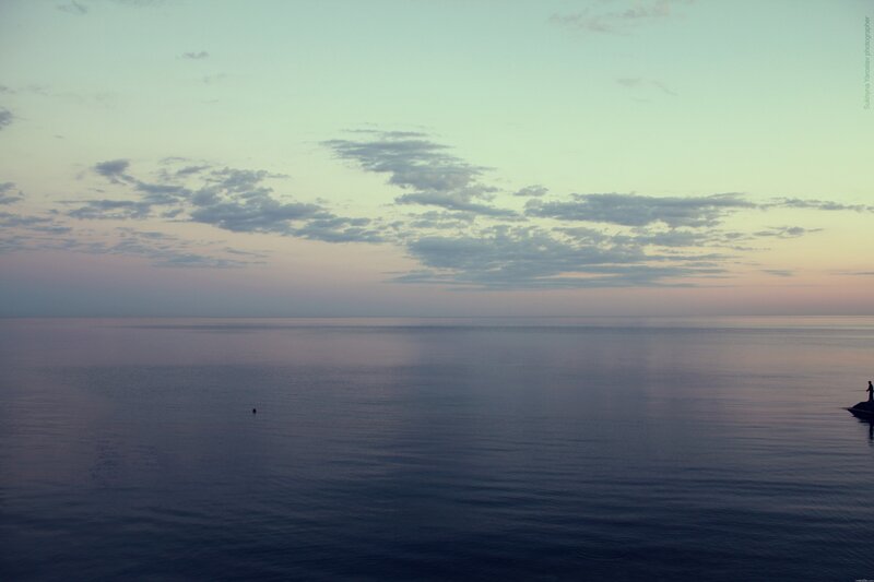 Person on a rock at dusk