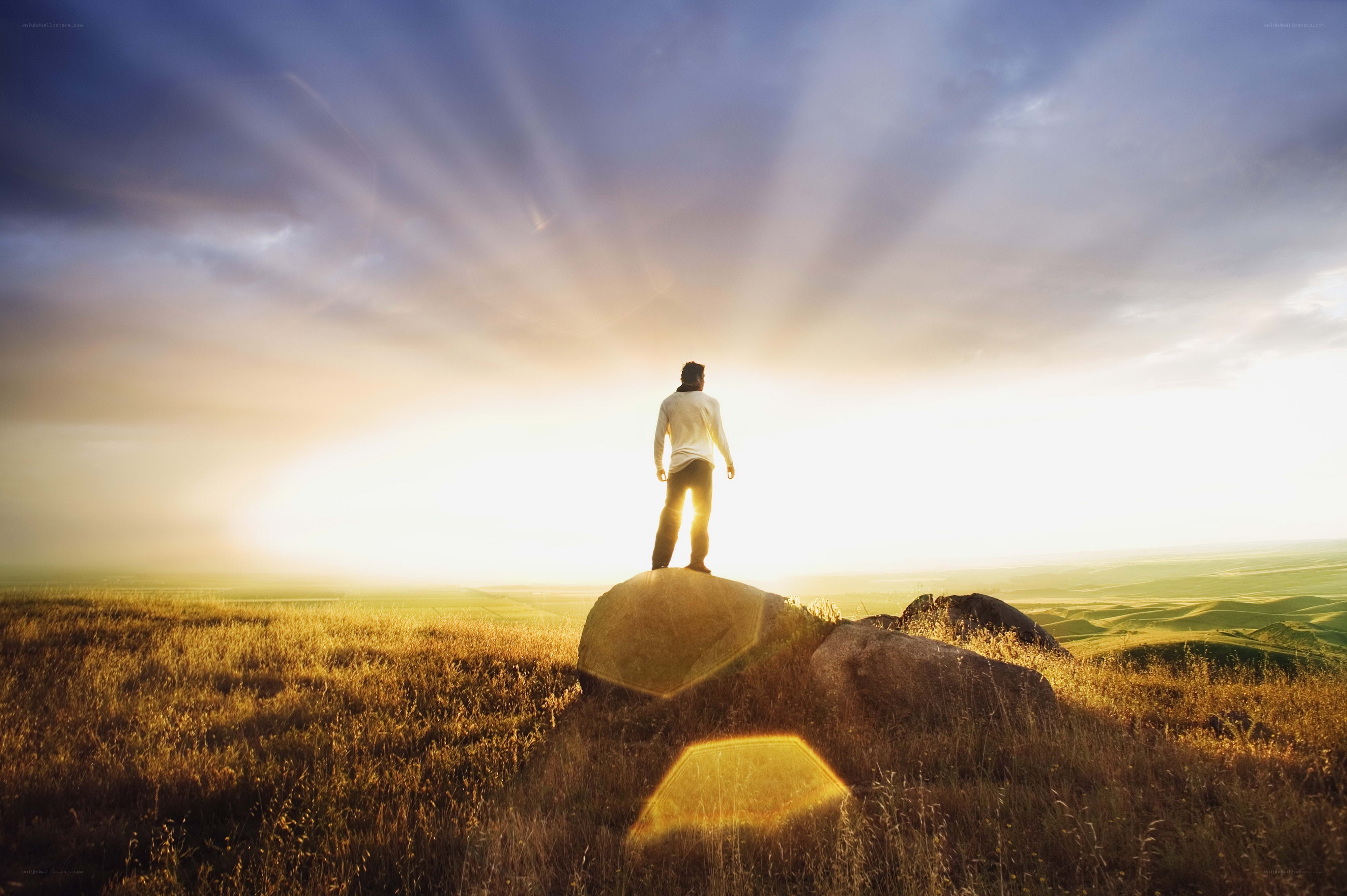 Person on a rock at sunset