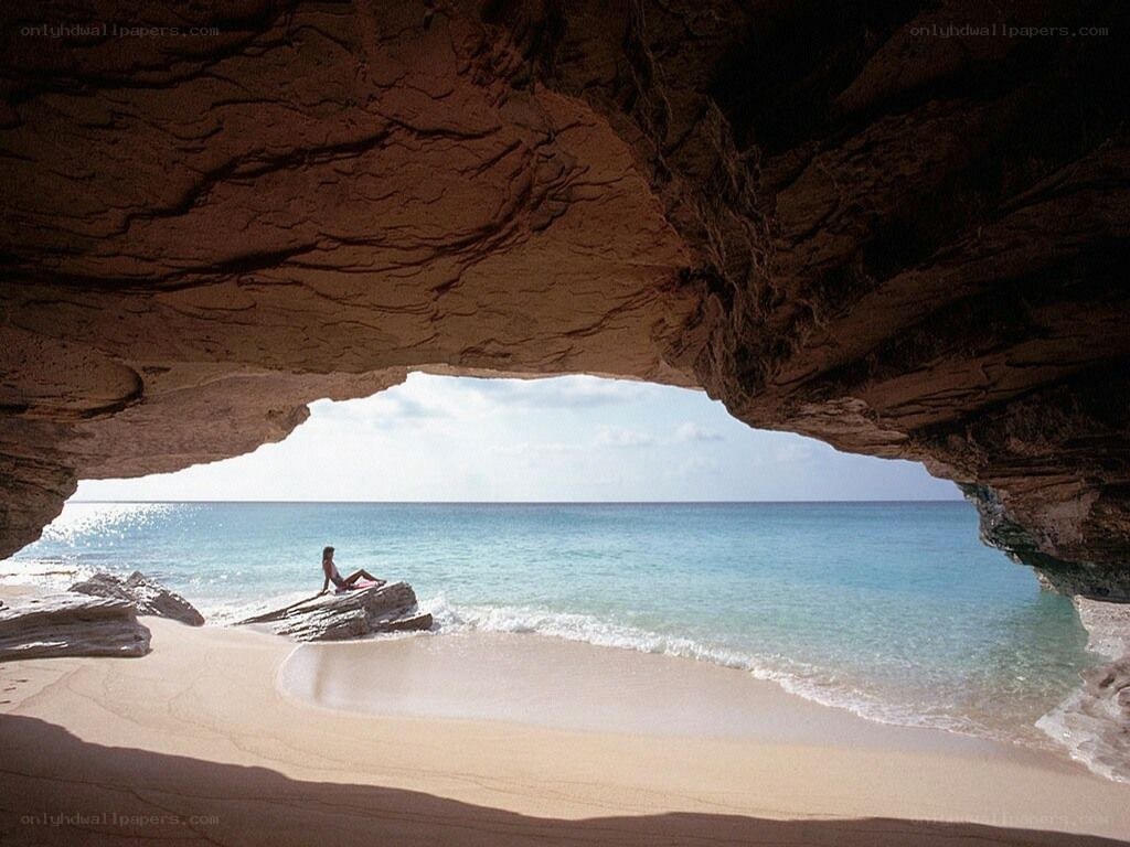 person on beach in cave
