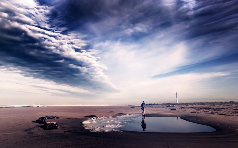 Person on Beach Near Lighthouse