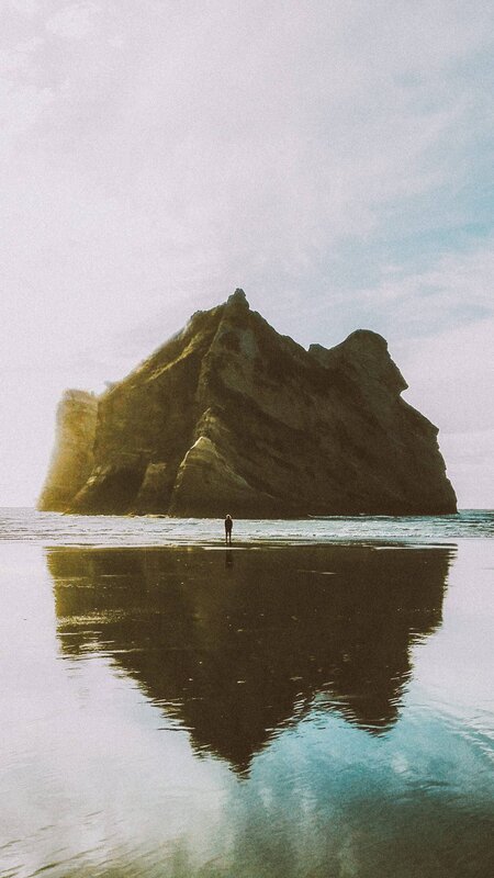 Person on Beach Near Rock — Brown