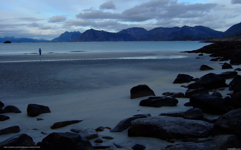 Person on beach with mountains