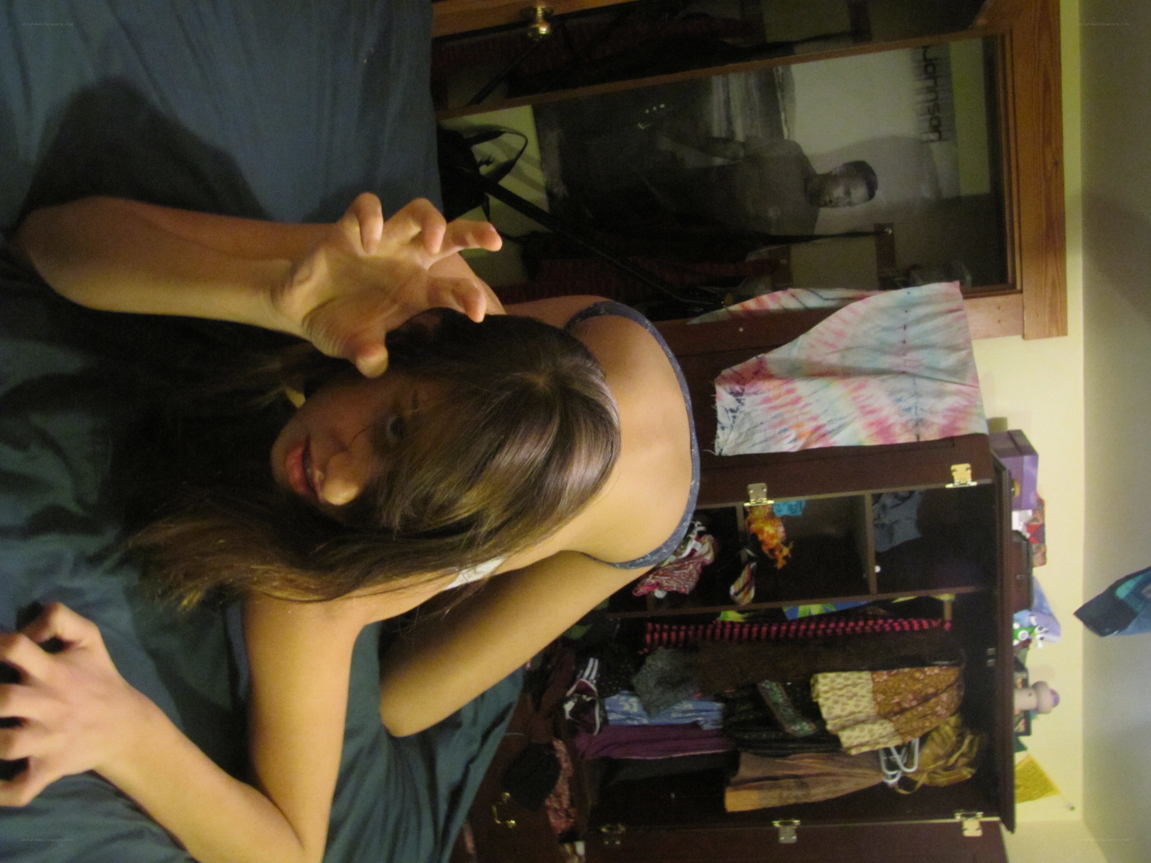 person on bed making hand gesture