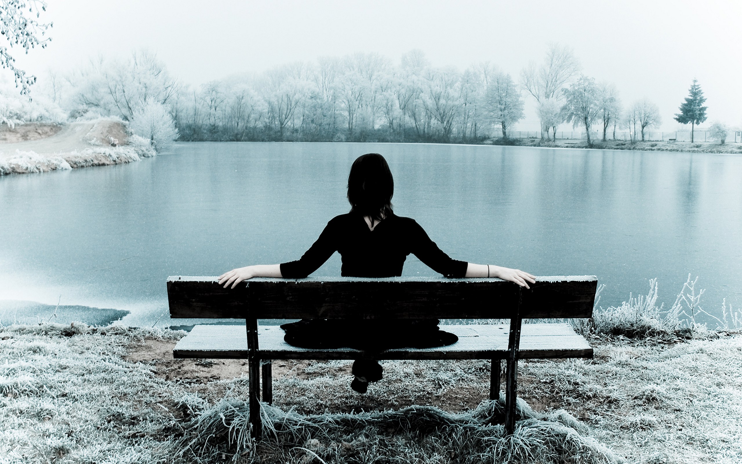 Person on bench by lake