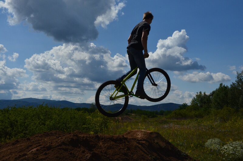 Person on Bicycle Mid-air — Blue, Dramatic, Afternoon